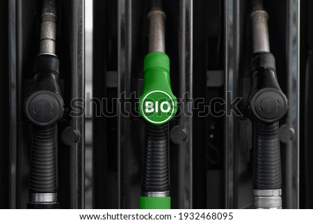 Fuel nozzles at a gas station. One nozzle green with text BIO. Royalty-Free Stock Photo #1932468095