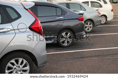 Closeup of back or rear side of soft blue car with  other cars parking in outdoor parking area in twilight evening. Royalty-Free Stock Photo #1932469424