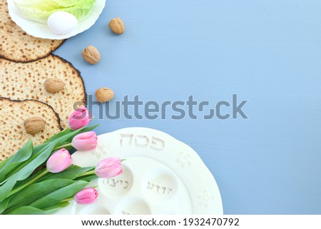 Pesah celebration concept (jewish Passover holiday). Traditional pesah plate text in hebrew: Passover, horseradish, celery, egg, bone, maror, sweet dates jam