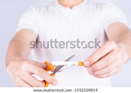Male hand using scissors cutting cigarette. World no Tobacco and stop smoking day.