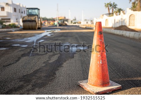 Close up of an orange traffic cone on the road copy space.
