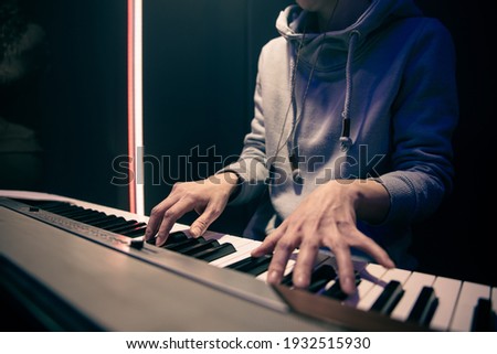 Female hands play the piano. Concept of music recording, rehearsal or live performance.