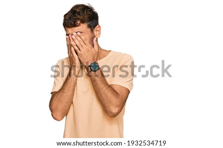 Handsome young man with beard wearing casual tshirt rubbing eyes for fatigue and headache, sleepy and tired expression. vision problem 