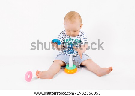 Little cute boy playing with children's multi-colored developing pyramid on an isolated white background, Early development, Preparing for kindergarten