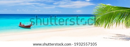 Panorama of thai traditional wooden longtail boat and beautiful sand beach in Koh Tao, Thailand. Vacation holidays summer background. View of nice tropical beach. Royalty-Free Stock Photo #1932557105