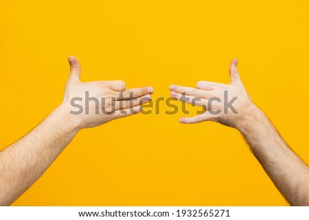 Hands of man make 
caricatures from the hand  on yellow background