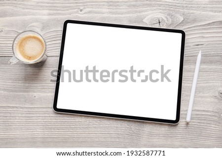 Tablet mockup with empty white screen and wireless stylus pen on table
