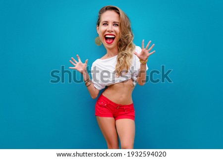 Funny expressing joy! Cartoon style Happy pretty young woman in shorts over green background. 