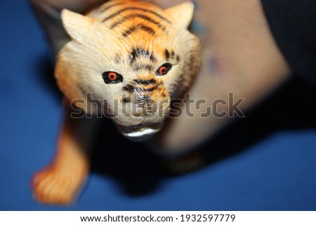 Little boy playing with toys.Tiger toy image, on blue background.
