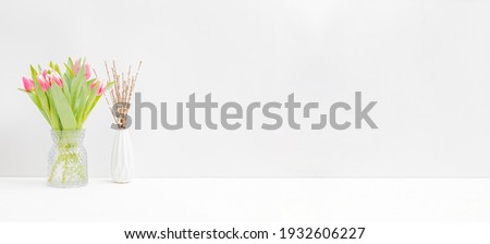 Home interior with easter decor. Pink tulips in a vase on a light background