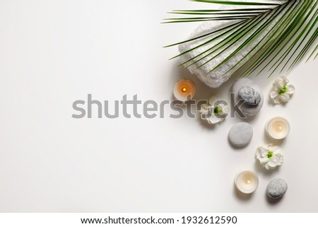 Composition with symbolic objects for spa salon. Stone therapy attributes for cosmetic procedures. Conceptual image, rocks and flowers representing balance. Close up, copy space, top view, background. Royalty-Free Stock Photo #1932612590
