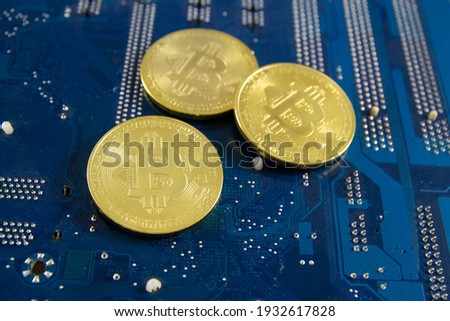 Golden coins with bitcoin symbol on a mainboard