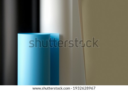 Three plastic backgrounds in white, black and blue in rolls. Copy space. Selective focus.                              
