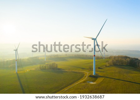 Panoramic view of wind farm or wind park, with high wind turbines for generation electricity with copy space. Green energy concept. Royalty-Free Stock Photo #1932638687