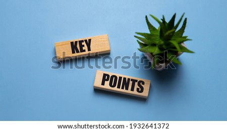 Key point on wooden cube on the background of a working man at a computer. Business success measurement goal and goal management concept