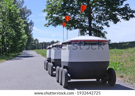 moving delivery robots on the road. Cyber-couriers are cruising the sidewalks in Estonia. Copy space for design. Modern delivery concept-robots delivery Royalty-Free Stock Photo #1932642725