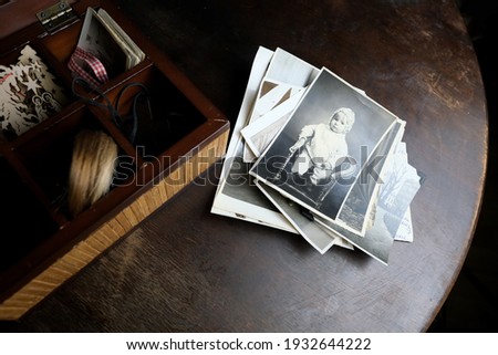 dear to heart memorabilia in an old wooden box, a stack of retro photos, vintage photographs of 1960, concept of family tree, genealogy, connection with ancestors