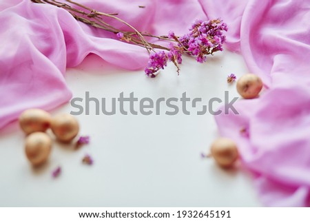 Minimalism background: greetings and presents for Easter Day in pink flat lay styling. Easter  banner with Easter eggs with copy space and dry flowers.