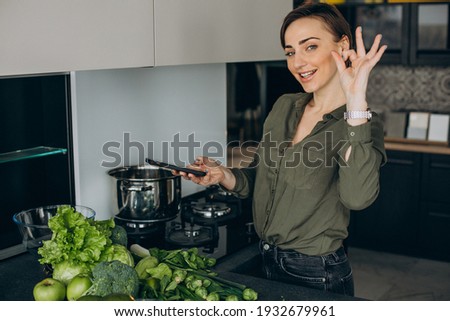 Woman making a photo of green vegetables on the table