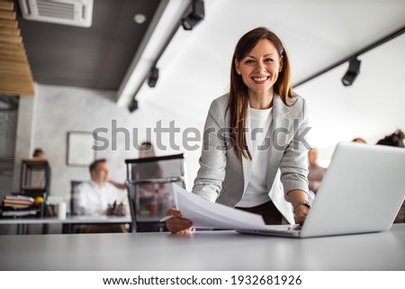Beautiful woman looking at camera, while searing something online.