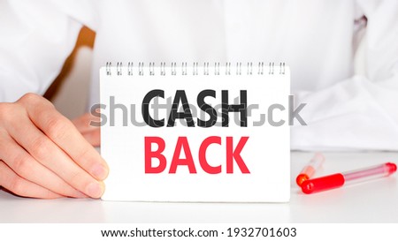On the table there is a red marker and a white paper tablet on which the text is written - CASH BACK, red and black letters. Business concept.