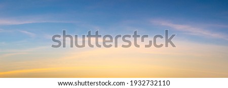 Beautiful sky painted by the sun leaving bright golden shades.Dense clouds in twilight sky in winter evening.Image of cloud sky on evening time.Evening sky scene with golden light from the setting sun Royalty-Free Stock Photo #1932732110