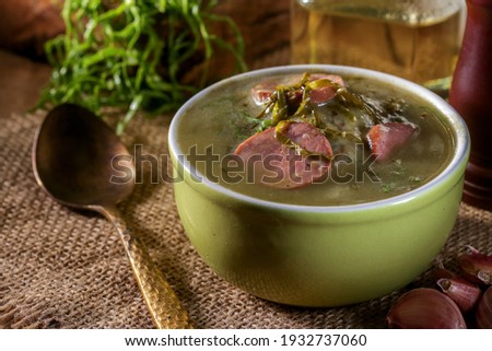 green broth with pepperoni and cabbage top view on rustic wooden table with selective focus and golden spoon 