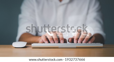 Customer support hotline Contact us people connection. Businessman using computer keyboard with the email, call phone, address, Chat message icons. Royalty-Free Stock Photo #1932737666