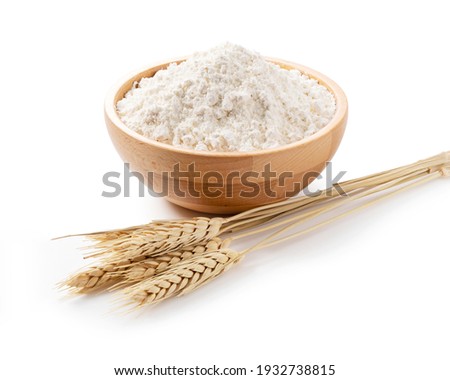 Ears of wheat and flour in a wooden bowl on a white background. Close-up, Material Photo Royalty-Free Stock Photo #1932738815