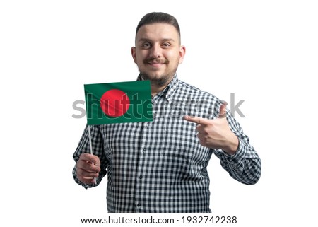 White guy holding a flag of Bangladesh and points the finger of the other hand at the flag isolated on a white background.