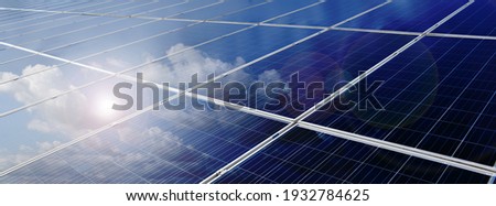 Photovoltaic rooftop or solar panels rooftop with reflection of the Sun and clouds on the surface, sustainable energy and eco friends concept. Royalty-Free Stock Photo #1932784625