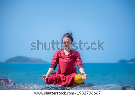 Sport woman wear India sport wear style posing practice yoga on beach in setting meditation pose ,yoga is healthy sport balance meditation body concept.  