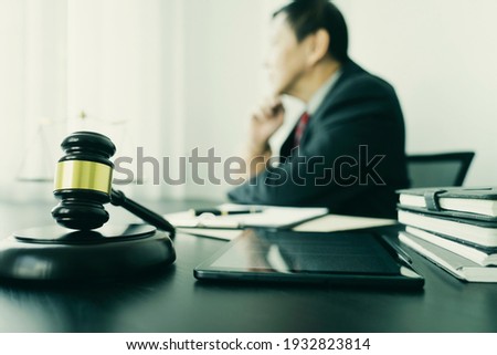 Focus on the gavel  attorneys or judge  sit and  thinking about the case at a desk with tablet in vintage tone with more copy space.
