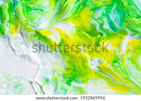 Abstract yellow-green acrylic background. Hand-drawn painting with liquid acrylic. Natural overflows. Spring art background. The technique of fluid art. Artistic author's style. Beautiful overflows
