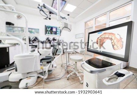 Interior of stomatology cabinet with modern equipment, dental intraoral scanner with teeth on display. Dental office with highly effective medical system for intraoral scanning. Concept of dentistry Royalty-Free Stock Photo #1932903641