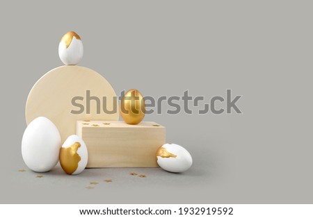 Mock up Easter composition with golden painted eggs and geometric shapes on grey background. Minimalist luxury concept for greeting card or sale. Creative eco  design.