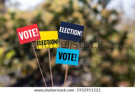 Election and Vote Words Written on Color Flags with Holding Sticks in Horizontal Orientation with Copy Space, Election Conceptual Photo
