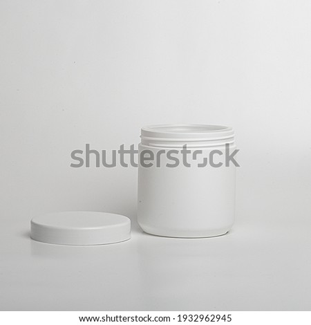 Packaging, container, cans for sports nutrition. Close-up. White plastic packaging with lid. Production.Folding top.Round jar.The set
