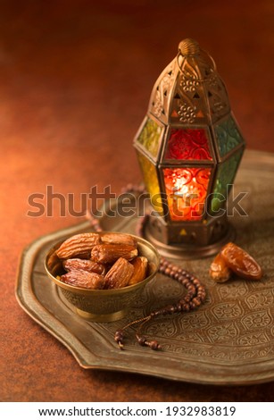 Fanoos. An illuminated Ramadan decorative lamp and dates in an old, antique tray.Ramadan background - stock photo