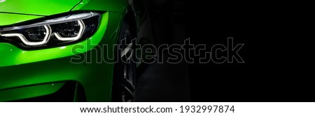 Close up detail green modern car headlights with led technology on black background free space on right side for text. Royalty-Free Stock Photo #1932997874