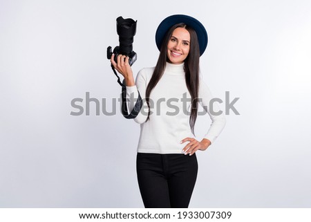 Photo of young attractive young woman hold hand camera waist wear hat creative job isolated on grey color background