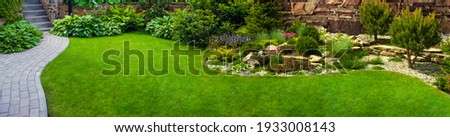 Garden stone path with grass growing up between the stones.Detail of a botanical garden. Royalty-Free Stock Photo #1933008143