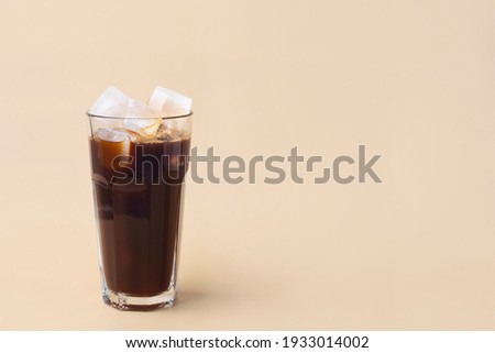 cold iced coffee on a beige background, minimalism, summer drink Royalty-Free Stock Photo #1933014002