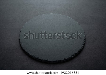 A round black slate dinner plate background