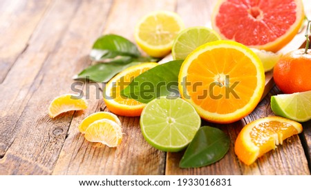 various citrus fruits on wood background Royalty-Free Stock Photo #1933016831