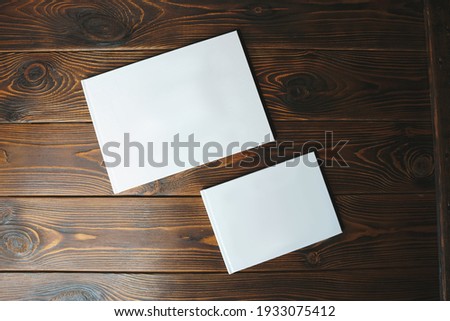white photobooks of different size on dark table