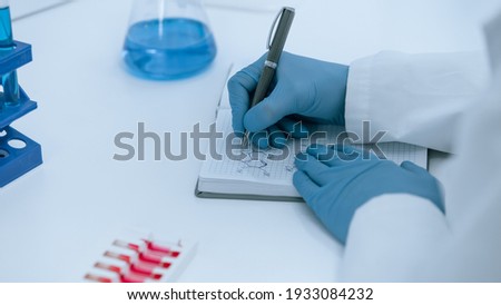 close up. scientist virologist recording test results in a journal.
