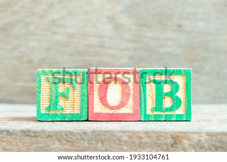 Color alphabet letter block in word FOB (Abbreviation of Free on Board) on wood background