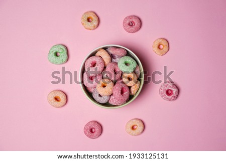 Colorful donuts with cute shapes in a bowl on a pink background. Sweet colorful donuts are perfect for snacks at home with your family and relatives. Delicious homemade sweet donuts.