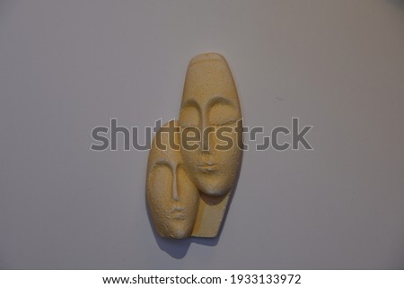 Head of a woman and a man in love and harmony from yellow sandstone.